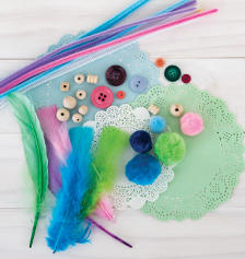 Art and craft supplies: feathers, buttons, straws and doilies.